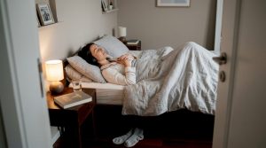 Mulher deitada no quarto, a meditar tranquilamente à noite.